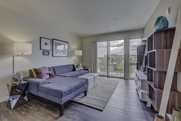 Seattle apartment for rent - A living room with a grey couch and a wooden floor.