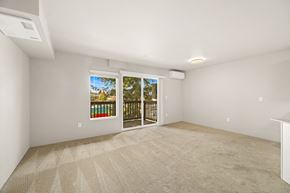 Seatac apartment for rent - A room with a carpeted floor and a sliding glass door leading to a balcony.