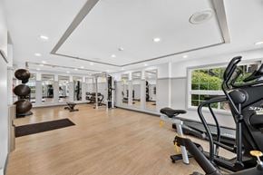 Lynnwood apartment for rent - A spacious gym with wooden floors and a variety of exercise equipment.