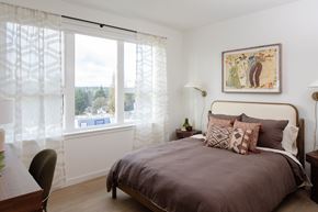 Shoreline apartment for rent - A bedroom with a large bed and a painting on the wall.