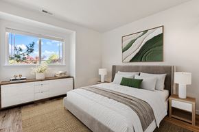 Vancouver townhouse for rent - A bedroom with a large bed, a nightstand with a lamp, and a painting on the wall.