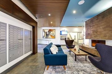 Seattle apartment for rent - A modern living room with a blue couch and a fireplace.