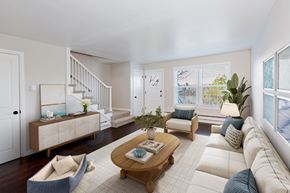 Bremerton apartment for rent - A living room with a white couch, a wooden coffee table, and a staircase.