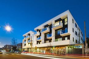 Portland apartment for rent - a rendering of a modern apartment building on a city street
