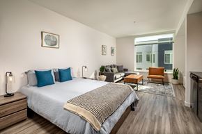 Tacoma apartment for rent - a bedroom with a bed and a couch in a room with a large window