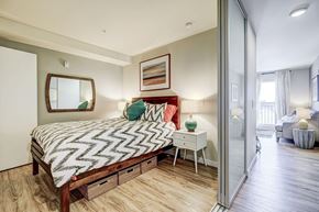 Seattle apartment for rent - A bedroom with a bed, nightstand, and a mirror on the wall.