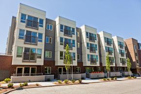 Seattle apartment for rent - A row of modern apartment buildings with balconies and trees in front.