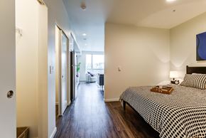 Seattle apartment for rent - a bedroom with a bed and a hallway to a bathroom