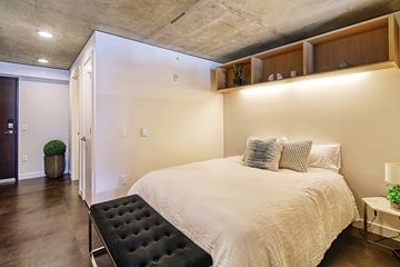 Seattle apartment for rent - A bedroom with a large bed and a black ottoman.