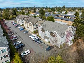 Seattle apartment for rent - A parking lot with cars and apartment buildings in the background.