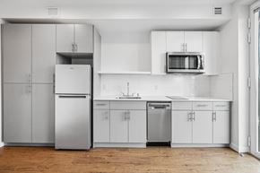 Seattle apartment for rent - a white kitchen with stainless steel appliances and white cabinets