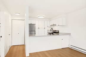 Seattle apartment for rent - A kitchen with white cabinets and a wooden floor.