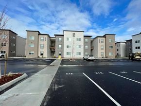 Tacoma apartment for rent - A parking lot in front of apartment buildings with a white car parked.