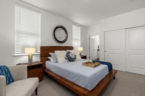 Lacey apartment for rent - A bedroom with a bed, nightstand, and chair.