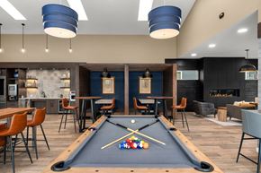 Lacey apartment for rent - A pool table is in the middle of a room with a bar and chairs.