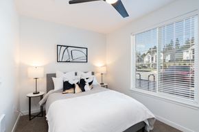 Olympia apartment for rent - a bedroom with a large window and a white bed