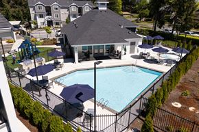 Olympia apartment for rent - a swimming pool in front of a house with umbrellas