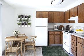 Vancouver apartment for rent - a small kitchen with a table and chairs and a white refrigerator