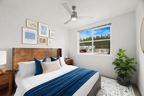 Arlington apartment for rent - A bedroom with a bed, a ceiling fan, and a window with a view of a parking lot.