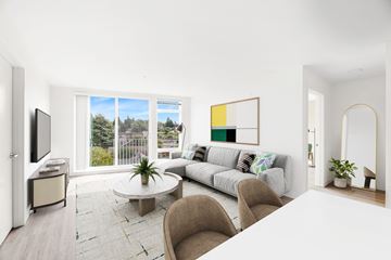 Seattle apartment for rent - A living room with a grey couch and a large window.