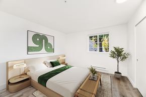 Lacey apartment for rent - A bedroom with a large bed and a green abstract painting above it.