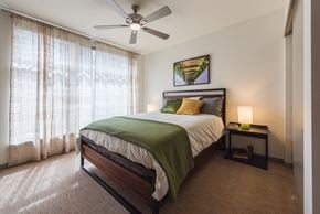 Seattle apartment for rent - A bedroom with a bed, a ceiling fan, and a painting on the wall.