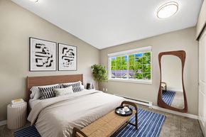 Bellevue townhouse for rent - A bedroom with a large bed and a mirror on the wall.