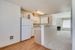 Poulsbo apartment for rent - an empty kitchen with white cabinets and a white refrigerator
