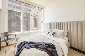 Seattle apartment for rent - a bedroom with a bed and a large window