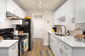 Everett apartment for rent - a kitchen with white cabinets and a black stove and refrigerator