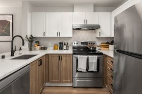 Seattle apartment for rent - a kitchen with stainless steel appliances and white cabinets