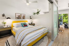 Seattle apartment for rent - a bedroom with a yellow bed and a sliding glass door