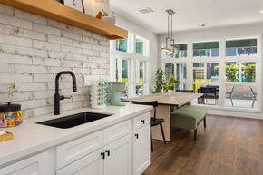Clackamas apartment for rent - a kitchen with white cabinets and a white brick wall