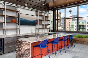 Seattle apartment for rent - a kitchen with a marble counter top and blue chairs