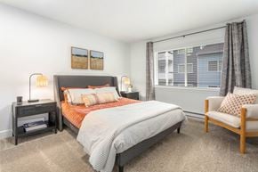 Burien apartment for rent - A bedroom with a bed, chair, and nightstand.