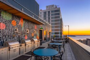 Seattle apartment for rent - a terrace with tables and chairs and a view of the ocean and a building