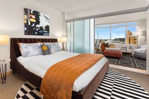Seattle apartment for rent - a bedroom with a bed and a view of a living room