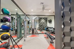 Seattle apartment for rent - a gym with weights and cardio equipment and a geometric wall in the back