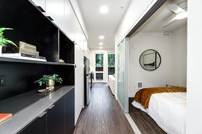 Seattle apartment for rent - a bedroom with a bed and a black wall and a door to a bathroom