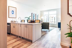 Seattle apartment for rent - a kitchen with a counter and a living room with a window