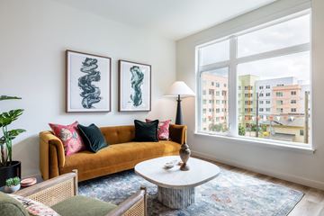 Seattle apartment for rent - A living room with a yellow couch and two framed artworks on the wall.