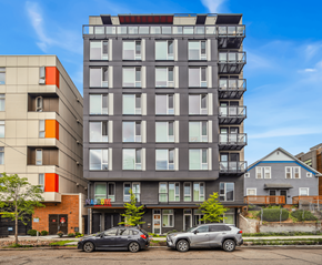 Seattle apartment for rent - Two cars are parked in front of a modern apartment building.