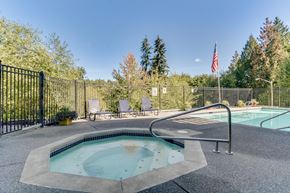 Poulsbo apartment for rent - a hot tub and a pool with a fence and an flag