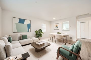 Olympia apartment for rent - A living room with a grey sofa, a green armchair, a wooden coffee table, and a painting on the wall.
