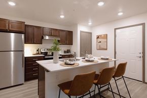Bremerton apartment for rent - a kitchen with a large island with four chairs