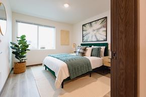 Bremerton apartment for rent - a bedroom with a bed and a potted plant
