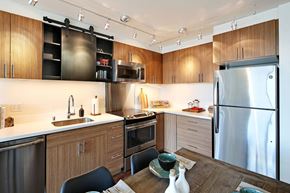 Seattle apartment for rent - a kitchen with stainless steel appliances and a wooden table