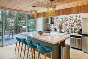 Kirkland apartment for rent - a kitchen with a large island with a marble countertop and blue chairs