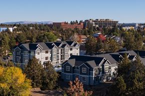 Bend apartment for rent - A cluster of houses with trees in the foreground.