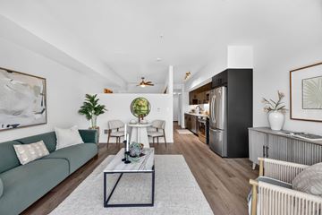 Seattle apartment for rent - A living room with a green couch, a coffee table, and a large painting on the wall.